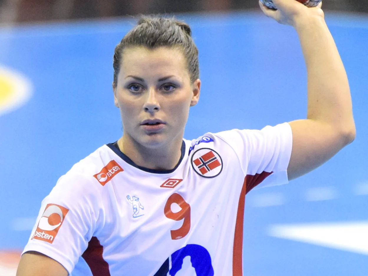 Nora Mørk i Norges vita landslagströja med nummer 9, med bollen höjd över huvudet.